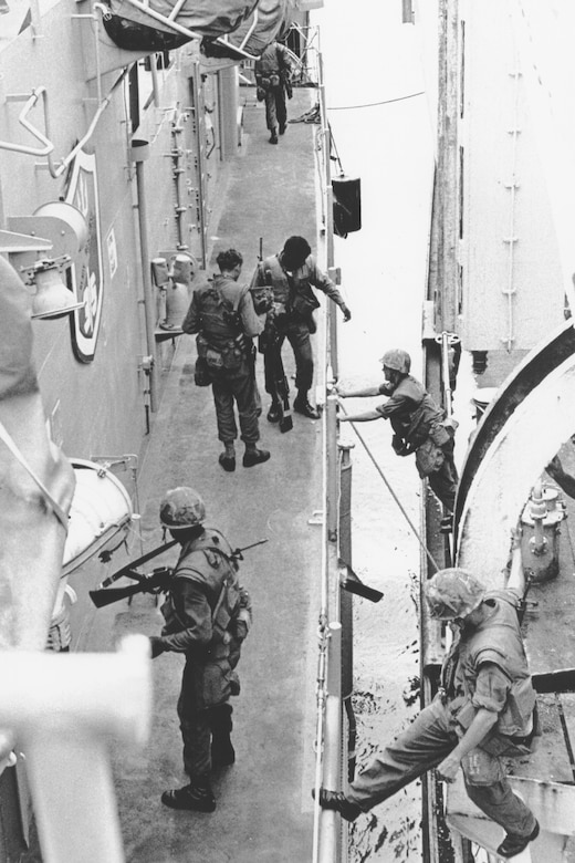 Military personnel move from one ship to another ship.