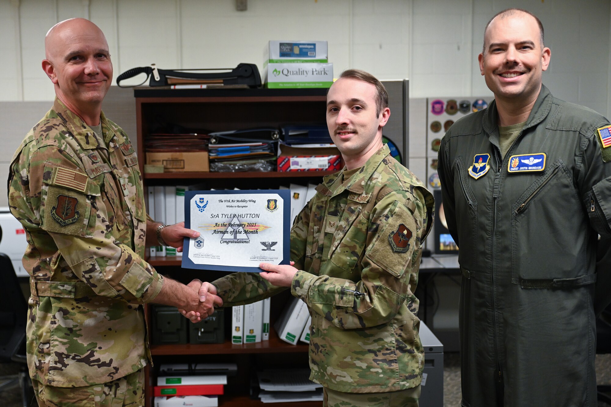 U.S. Air Force Col. Jeff Marshall, 97th Air Mobility Wing (AMW) commander, left, and Chief Master Sgt. Justin Brundage, 97th AMW command chief, right, award Senior Airman Tyler J. Hutton 97th Healthcare Operations Squadron medical readiness technician, at Altus Air Force Base, Oklahoma, March 24, 2025. Hutton earned the award by striving for excellence in his job and providing critical leadership during the Sustainment Operations for Air Force Medical Responders exercise. (U.S. Air Force photo by Airman 1st Class Nathan Langston)