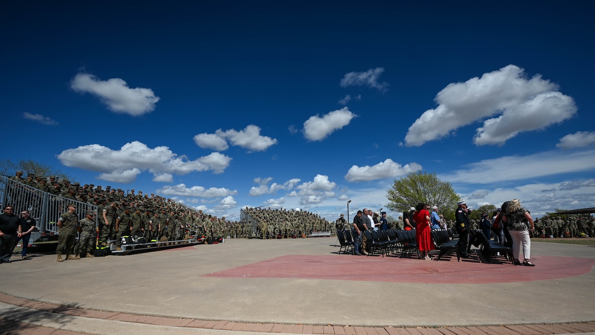 Members of the crowd attending the annual Department of Defense Fallen Firefighter Memorial Service stand during the playing of the National Anthem at the Fire Protection Heritage Pathway, Goodfellow Air Force Base, Texas, March 28, 2025. The memorial symbolizes the heroism and sacrifice of DOD firefighters who gave their lives in the line of duty. (U.S. Air Force photo by Staff Sgt. Nathan Call)
