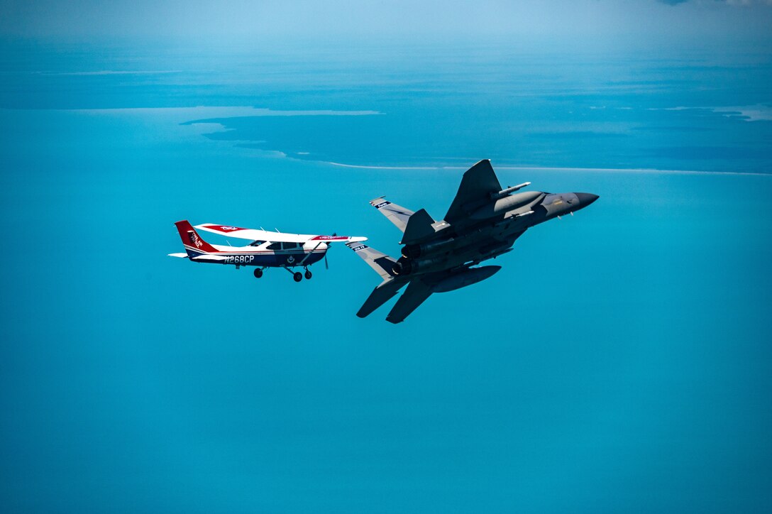 An F-15 fighter jet from the Florida Air National Guard’s 125th Fighter Wing, Detachment 1, intercepted a simulated Temporary Flight Restriction violator during a demonstration near Homestead Air Reserve Base, Florida, March 26, 2025. The exercise, coordinated with a Civil Air Patrol Cessna, highlighted the importance of TFR compliance and the teamwork and precision of NORAD pilots tasked with protecting North American airspace.