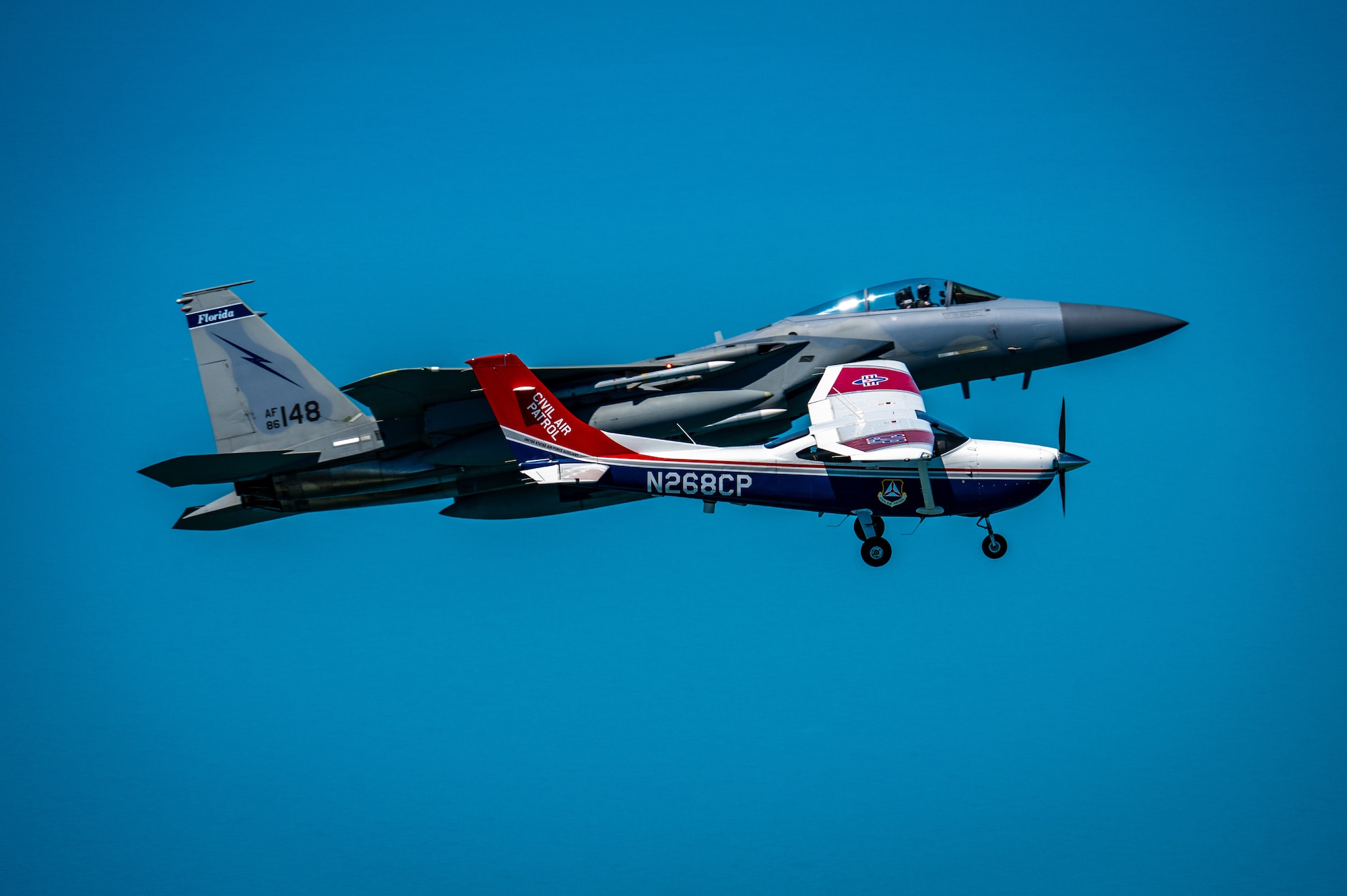 An F-15 fighter jet from the Florida Air National Guard’s 125th Fighter Wing, Detachment 1, intercepted a simulated Temporary Flight Restriction violator during a demonstration near Homestead Air Reserve Base, Florida, March 26, 2025. The exercise, coordinated with a Civil Air Patrol Cessna, highlighted the importance of TFR compliance and the teamwork and precision of NORAD pilots tasked with protecting North American airspace.