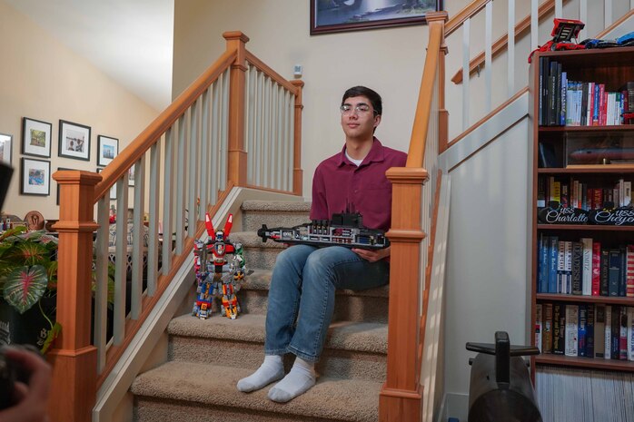 Henry Maxwell poses for a photo with a model submarine and Transformer robot in his family home, March 22, 2025. Maxwell attributes the Transformers movies in part to sparking his desire to serve. Maxwell was accepted to the U.S. Naval Academy and will become a midshipman in June joining the class of 2029. (U.S. Navy photo taken by Lt. Zachary Anderson)