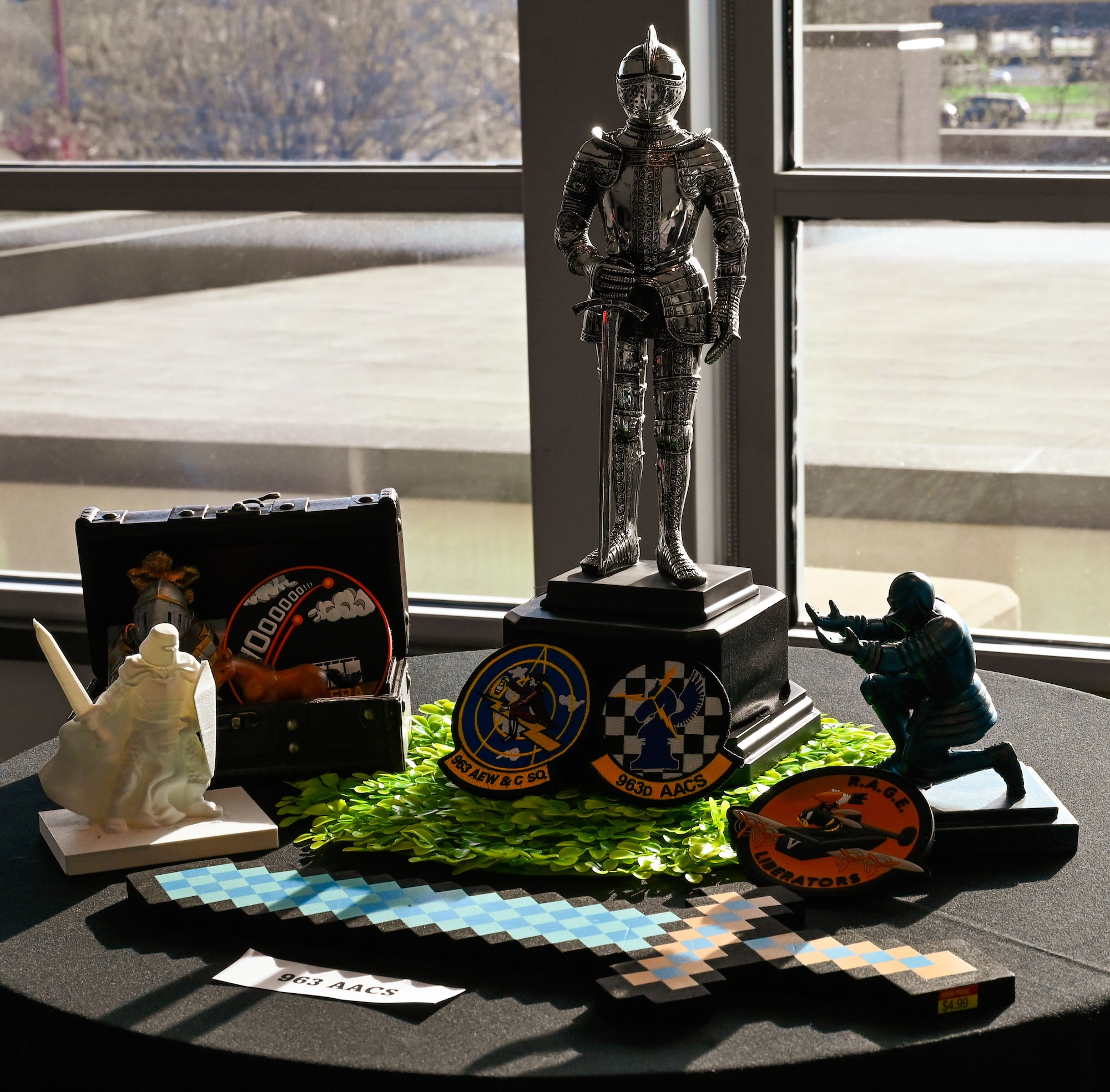 A knight statue and toy soldier stand among patches and props on the 963rd Airborne Air Control Squadron’s banquet table at the 552nd ACW 70th Anniversary event, March 27, 2025. Squadrons brought their identities to life through imaginative centerpiece designs.
(U.S. Air Force photo by Garrett N. Cole)