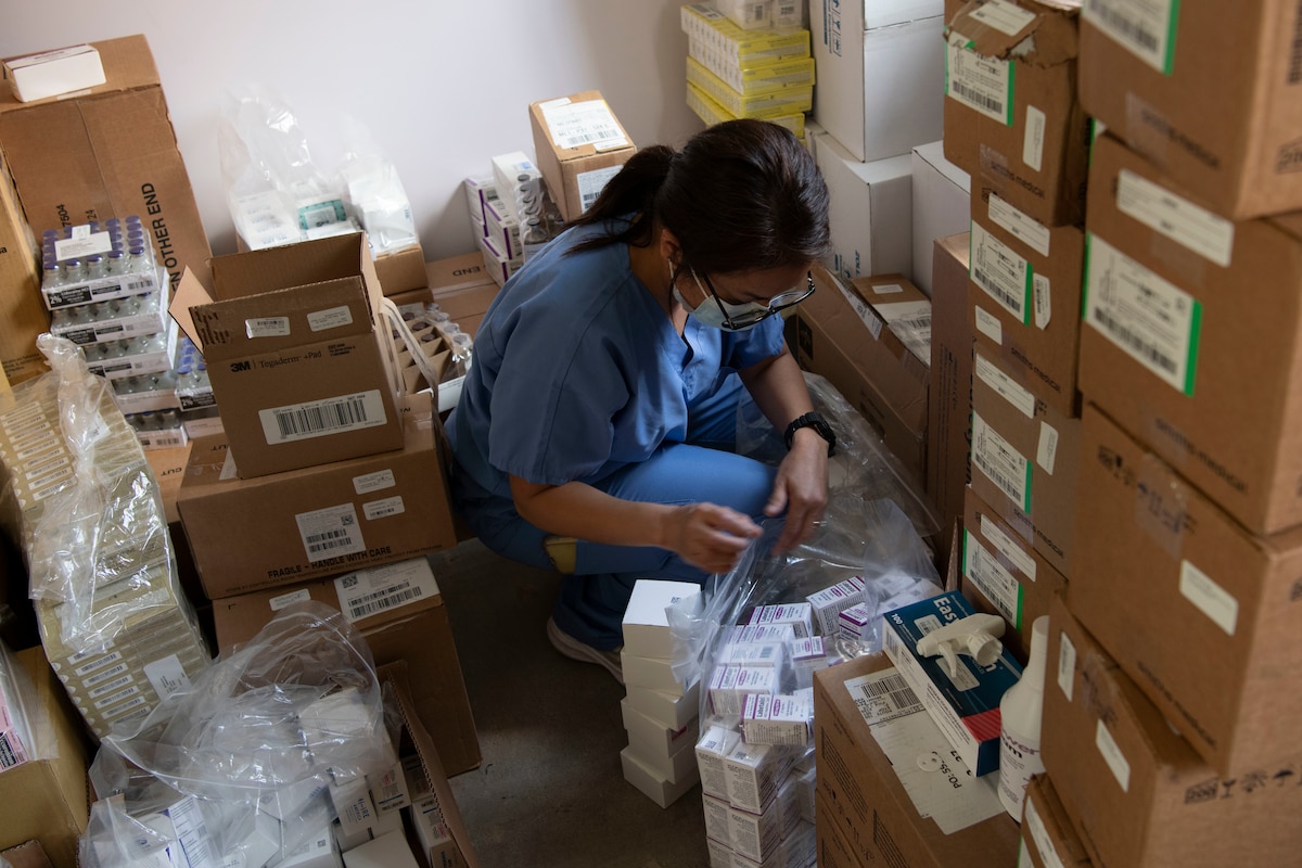 An Airman sorting through packages for medical treatment.