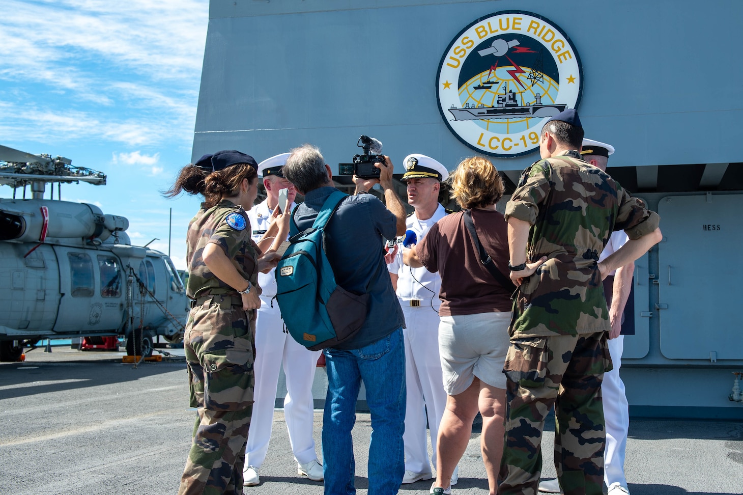 250426-N-BW367-1232 NOUMÉA, New Caledonia (April 26, 2025) – Capt. Nicholas Deleo, commanding officer of the U.S. 7th Fleet flagship USS Blue Ridge (LCC 19) speaks with members of the media and French Armed Forces New Caledonia on the ship’s flight deck during a scheduled port visit in Nouméa, New Caledonia, April 26, 2025. The Blue Ridge and embarked U.S. 7th Fleet staff conduct regular Indo-Pacific patrols to deter aggression, strengthen alliances and partnerships, and advance future warfighting capabilities. (U.S. Navy photo by Mass Communication Specialist Seaman Nicholas Douglass.)