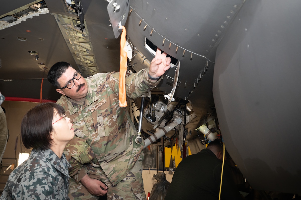 U S Air Force Master Sergeant Mark Turner, 35th Maintenance Squadron lead production superintendent, teaches a Japan Air Self Defense Force member about a U S Air Force F 16 Fighting Falcon during an immersion tour at Misawa Air Base, Japan.
