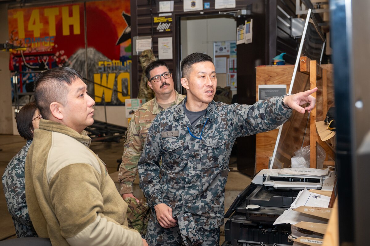 A Japan Air Self Defense Force member asks Tech Sergeant Ernest Mercado, left, 14th Fighter Generation Squadron inspection dock chief, about maintenance procedures during an immersion tour at Misawa Air Base, Japan.