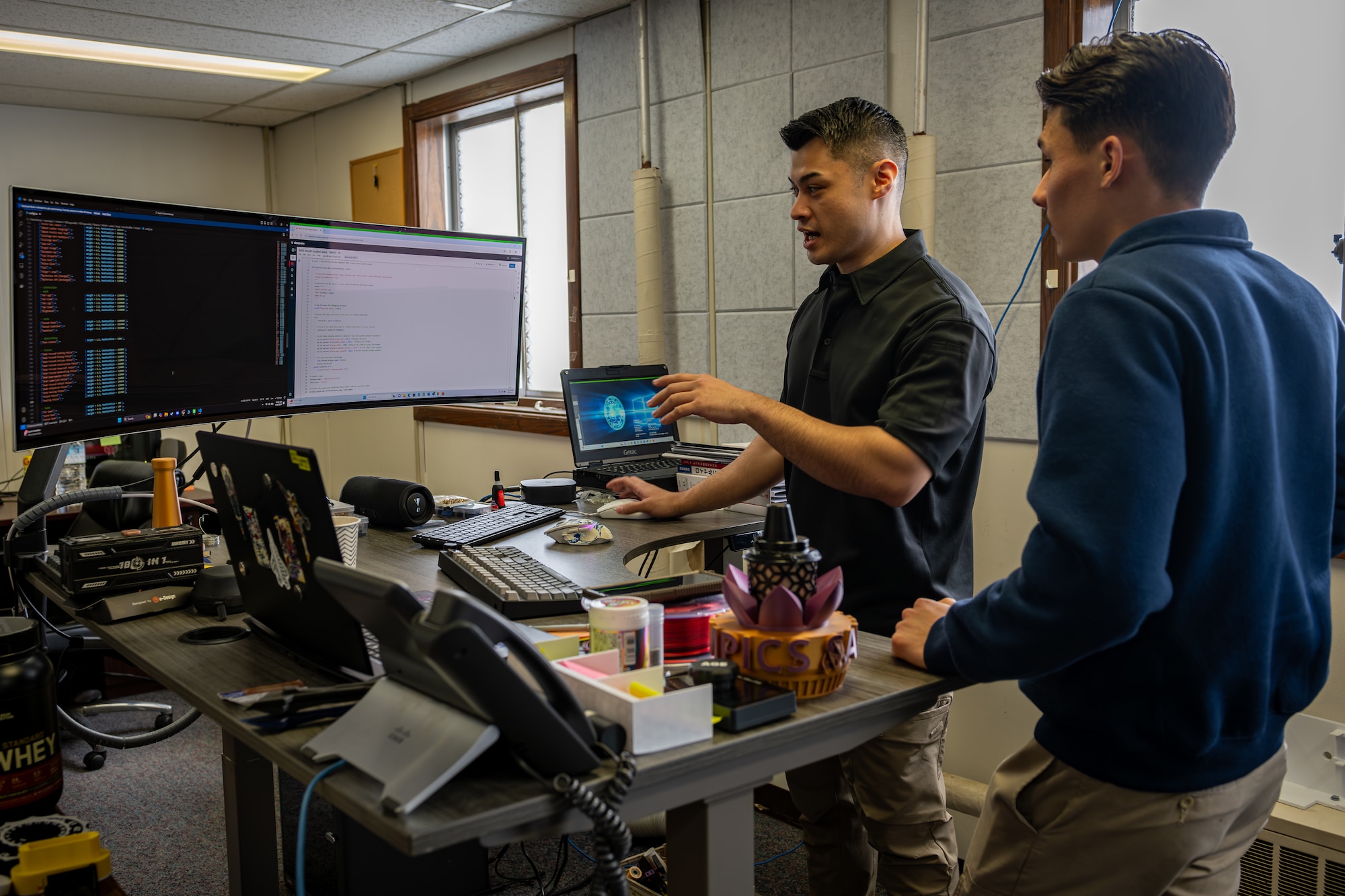 A man teaches his colleague about coding.