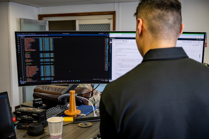 A man checks coding at a computer.
