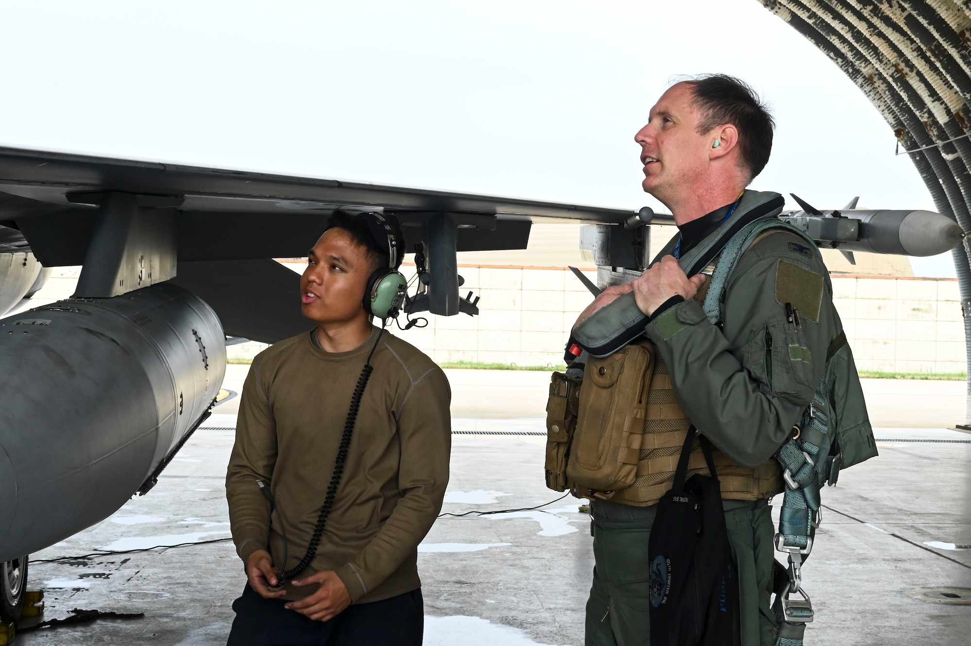 U.S. Air Force Col. Peter "Wolf" Kasarskis, 8th Fighter Wing commander, speaks with Airman 1st Class Matthew Navarro, 35th Fighter Generation Squadron F-16 Fighting Falcon crew chief, before performing pre-flight checks during exercise Freedom Flag 25-1 at Kunsan Air Base, Republic of Korea, April 23, 2025.