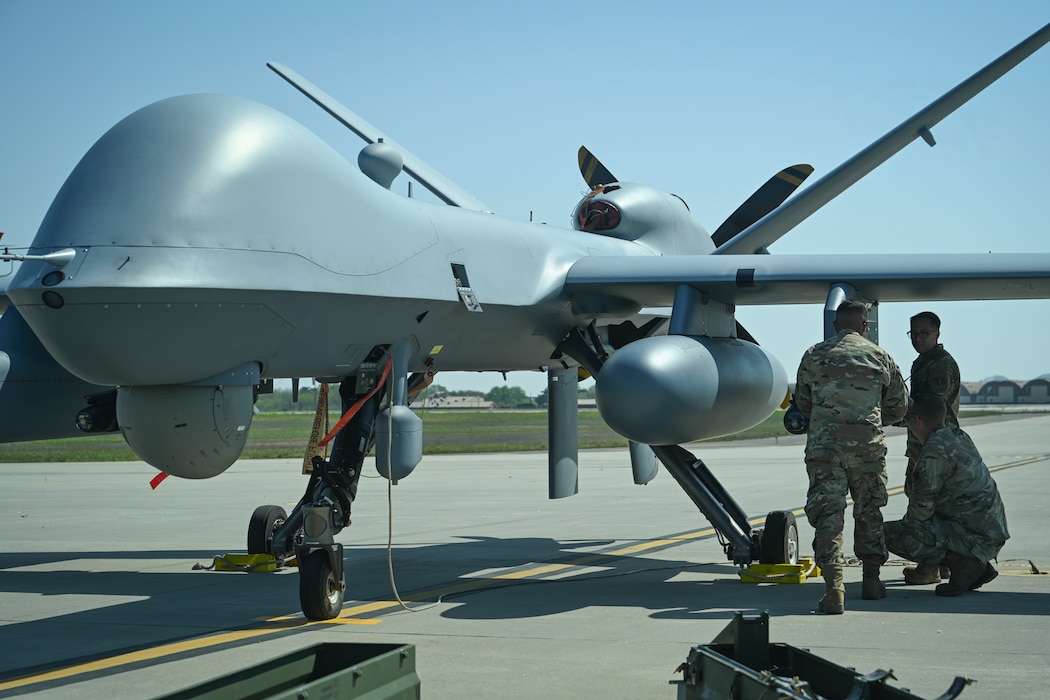 Senior Airman Eduardo Ledezma, Tech. Sgt. Kristopher Speir, and Tech Sgt. Aldrich Aldana, 163d Attack Wing MQ-9 Reaper armament systems specialists, load an AGM-114 Hellfire missile onto an MQ-9 Reaper at Kunsan Air Base.