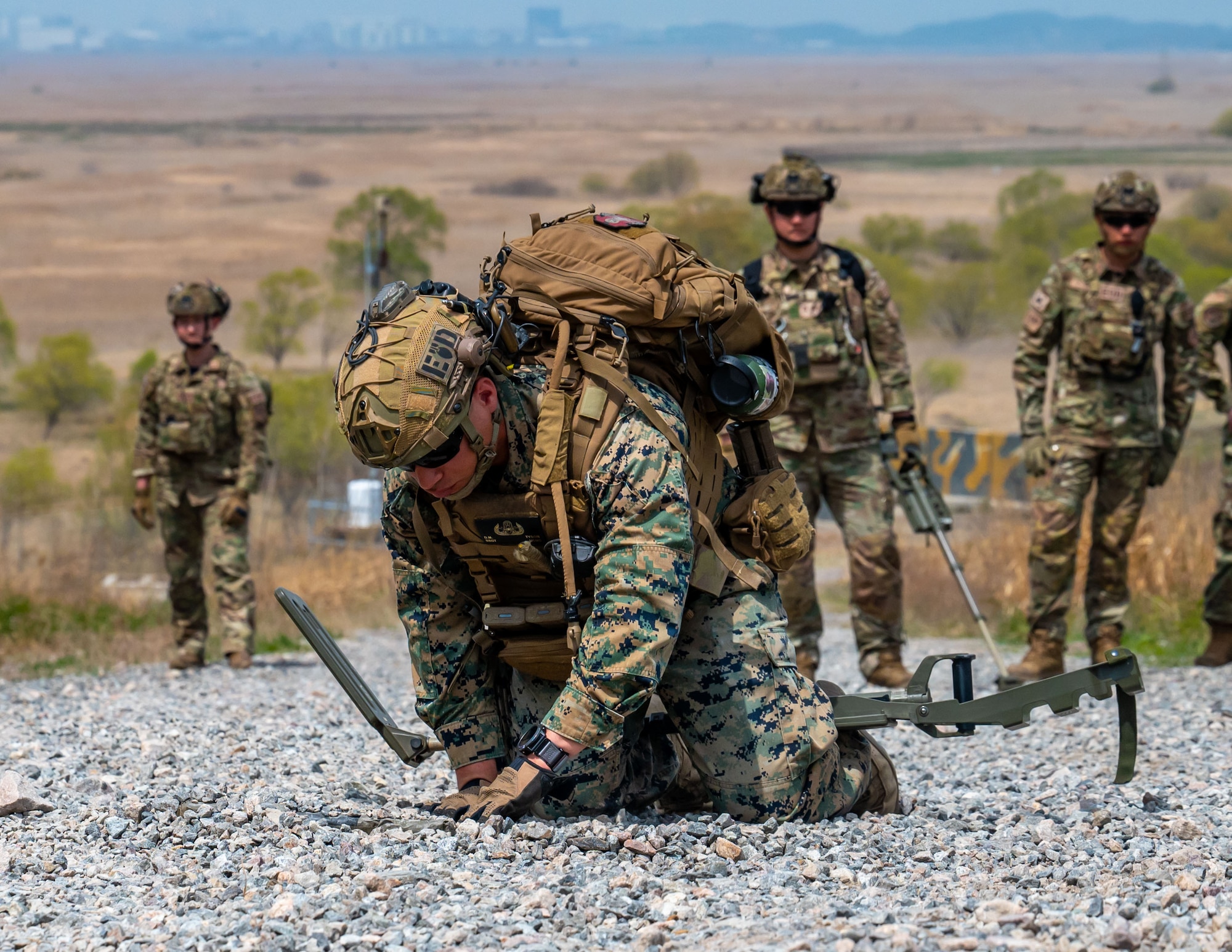An U.S. Marine EOD technician uncovers identifies a buried pressure plate.