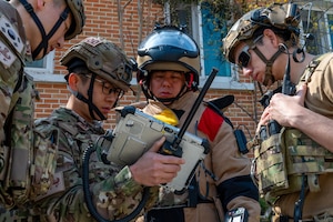 U.S. Air Force Airman and Republic of Korea Airmen use an X-ray machine to analyze a suspicious package.