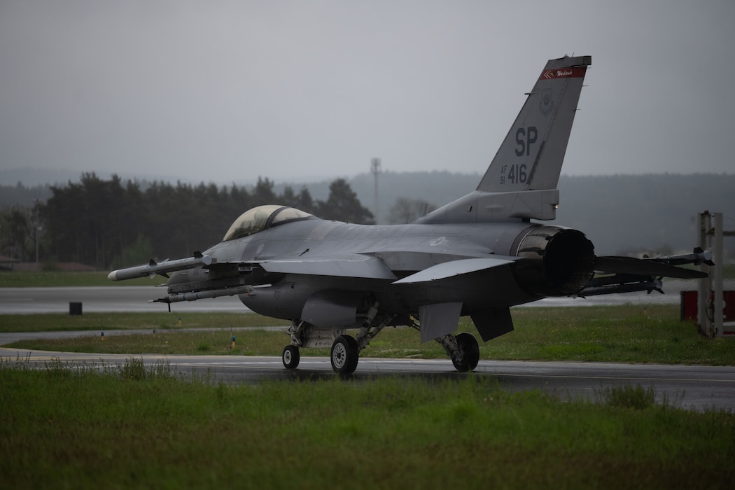 A fighter jet taxis down a runway.
