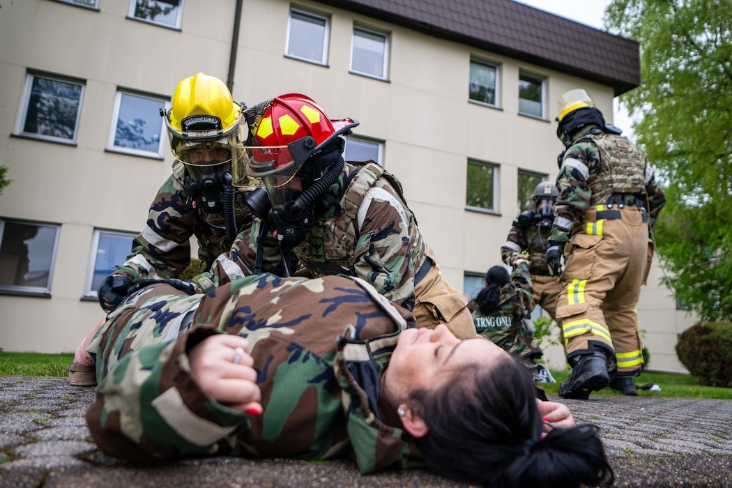 Firefighters in hazmat suits treat patients