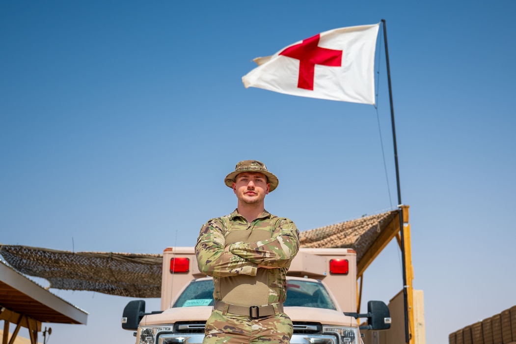 An Airman poses for a portrait in front of an ambulance.
