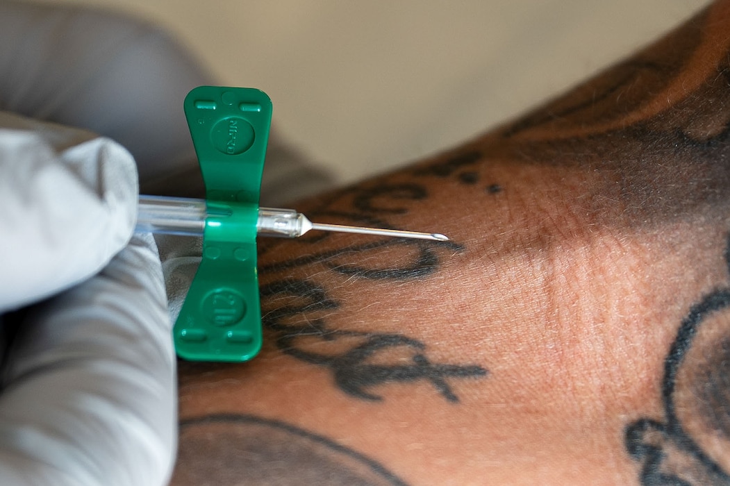 A winged infusion set is prepared to go into a patient's arm.