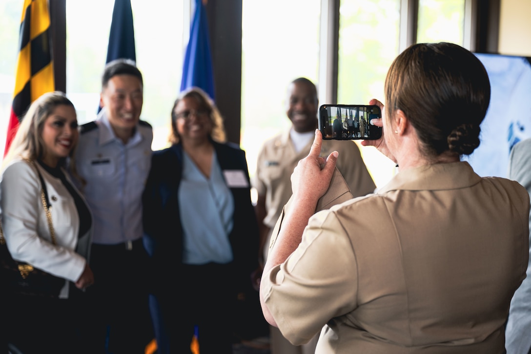 U.S. Navy Capt. Page Felini takes a photo of military and civilian leaders.