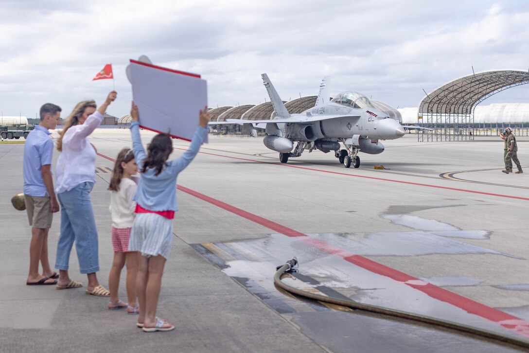 Family members of U.S. Marine Corps Lt. Col. Jarrod Allen, from California, commanding officer of Marine All-Weather Fighter Attack Squadron (VMFA(AW)) 224, watch as he taxis an F/A-18 Hornet during the squadron's final flight ceremony at Marine Corps Air Station (MCAS) Beaufort, South Carolina, April 28, 2025. The flight concluded their return from the Weapons and Tactics Instructor course at MCAS Yuma, Arizona, and commemorated the end of VMFA(AW)-224’s operational history with the F/A-18 Hornet as the unit begins its transition to the F-35B Lightning II. (U.S. Marine Corps photo by Lance Cpl. Julius Hackney)