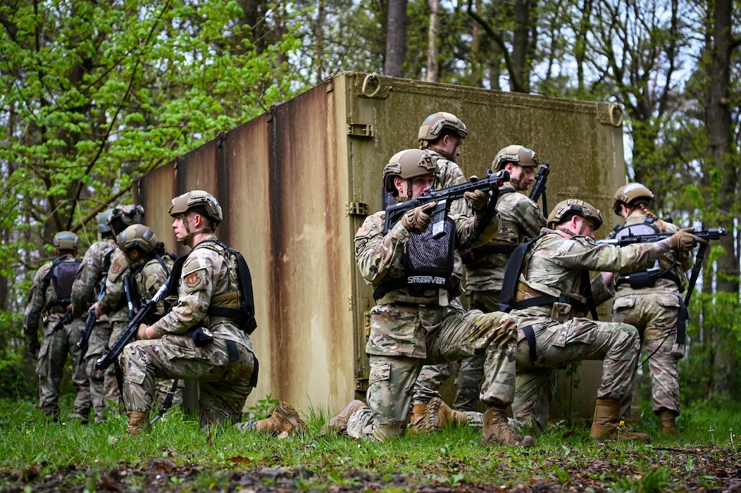 Military policemen pull security around a hardened facility in a wooded area.
