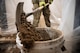Broken-up concrete is shoveled into a bucket.