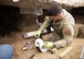 An Airman prepares PVC pipes inside a hand-excavated command suite.