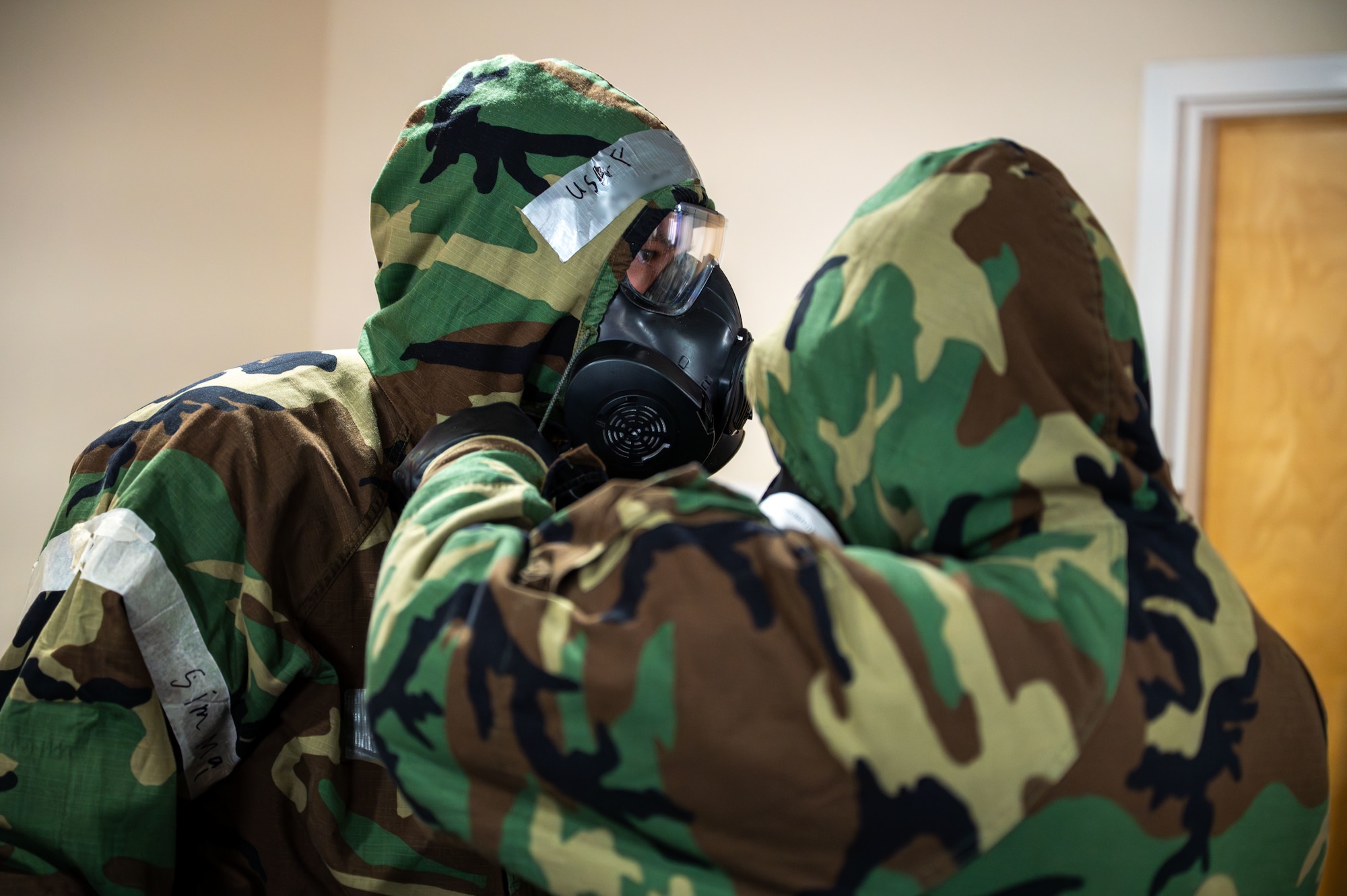 U.S. Airmen assigned to the 11th Combat Air Base Squadron perform buddy checks on their chemical, biological, radiological and nuclear gear at Davis-Monthan Air Force Base, Arizona, April 28, 2025. The training reinforced critical response skills in the event of a CBRN attack. (U.S. Air Force photo by Senior Airman Jasmyne Bridgers-Matos)