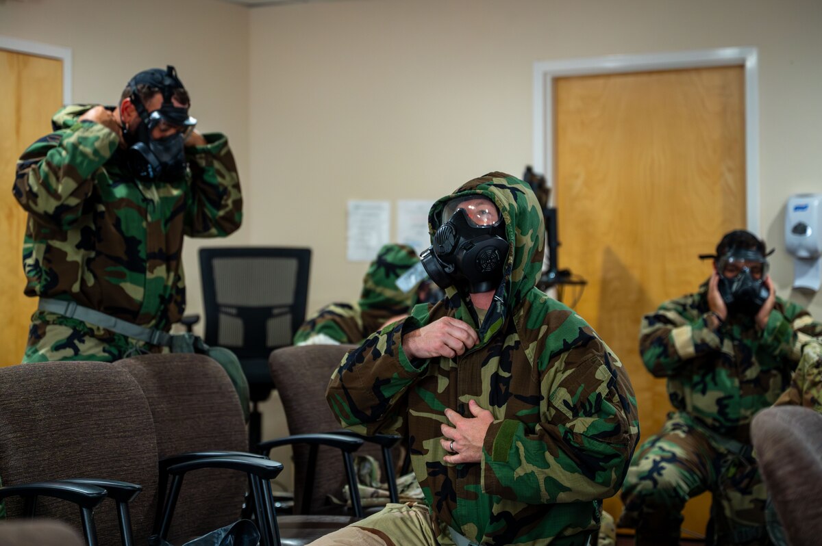 U.S. Airmen with the 11th Combat Air Base Squadron practice equipping chemical, biological, radiological and nuclear protective gear at Davis-Monthan Air Force Base, Arizona, April 28, 2025. Hands-on training honed essential skills for surviving and sustaining operations in CBRN environments. (U.S. Air Force photo by Senior Airman Jasmyne Bridgers-Matos)