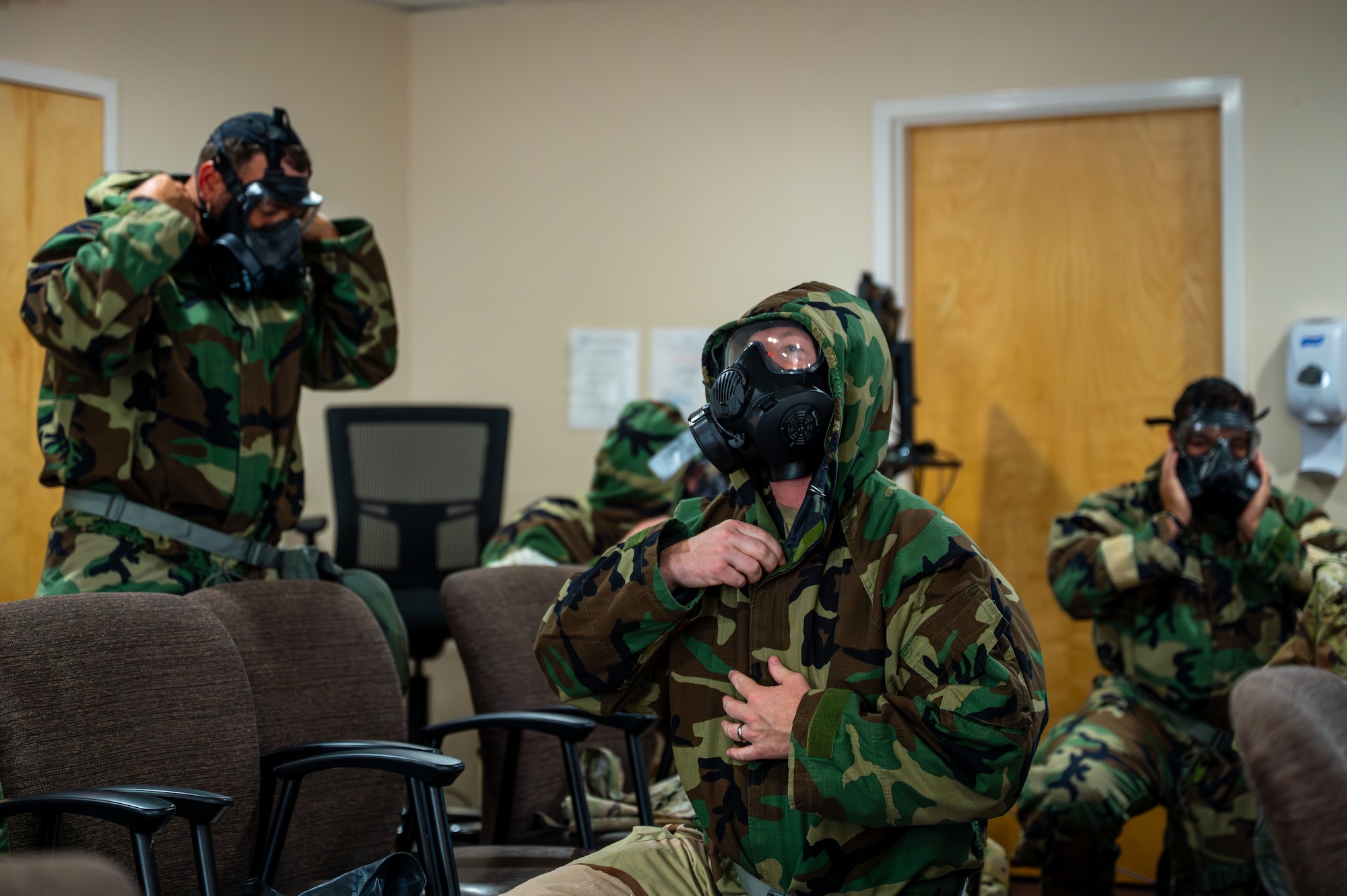 U.S. Airmen with the 11th Combat Air Base Squadron practice equipping chemical, biological, radiological and nuclear protective gear at Davis-Monthan Air Force Base, Arizona, April 28, 2025. Hands-on training honed essential skills for surviving and sustaining operations in CBRN environments. (U.S. Air Force photo by Senior Airman Jasmyne Bridgers-Matos)