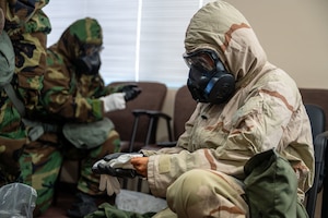 A U.S. Airman assigned to the 11th Combat Air Base Squadron dons their gloves during chemical, biological, radiological and nuclear training at Davis-Monthan Air Force Base, Arizona, April 28, 2025. Training reinforced proper attention to detail needed to maintain full-body coverage. (U.S. Air Force photo by Senior Airman Jasmyne Bridgers-Matos)