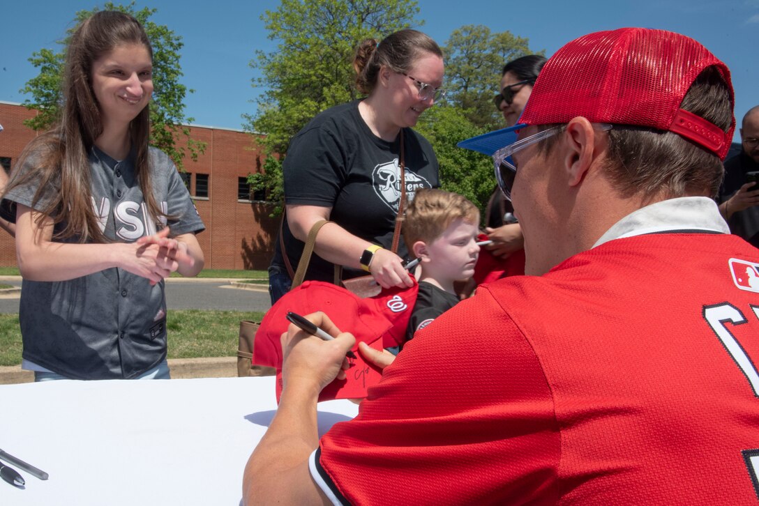 Alex Call, an outfielder with the Washington Nationals, signs an autograph for a young fan at Joint Base Andrews, Md., April 23, 2025.