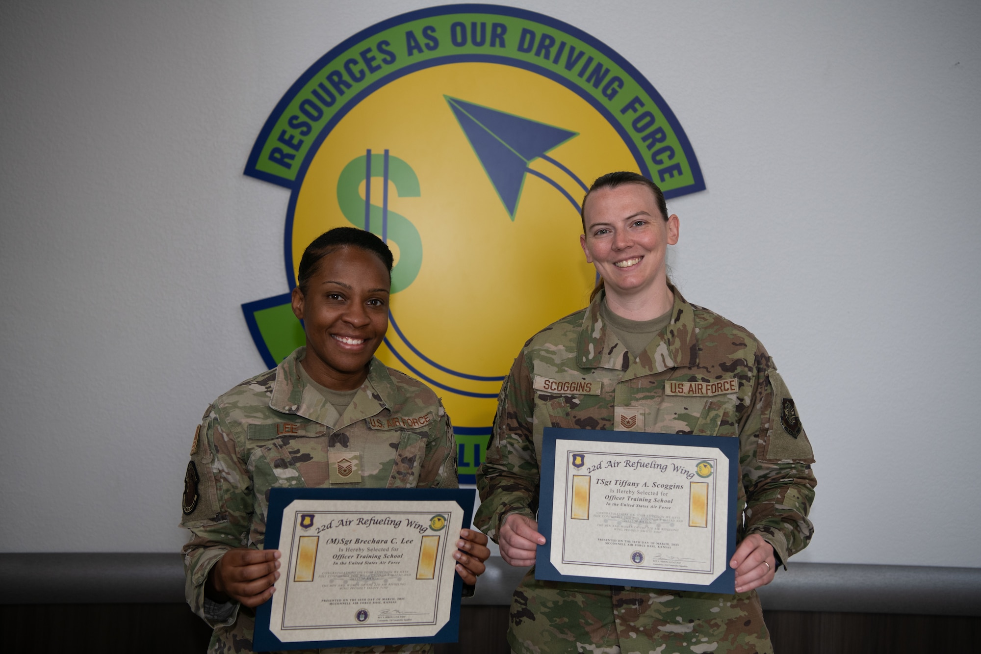 Master Sgt. Brechara Lee, 22nd Comptroller Squadron financial management analysis flight chief, and Tech. Sgt. Tiffany Scoggins, 22nd CPTS financial management analysis non-commissioned officer in charge, hold their officer training school acceptance certificates on April 23, 2025, at McConnell Air Force Base, Kansas. Lee and Scoggins were notified the same day they were accepted into OTS. (U.S. Air Force photo by Senior Airman Amelio Brown)