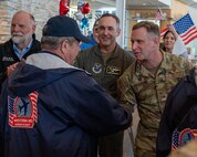 Veterans with the Western North Dakota Honor Flight are greeted by Col. Jesse Lamarand, 5th Bomb Wong commander (center), and Col. James Schlabach, 91st Missile Wing Commander (right), at Minot International Airport in Minot, N.D., April 28, 2025. The group returned from a two-day trip to Washington, D.C., where they visited war memorials and national landmarks built in their honor. (U.S. Air Force photo by Airman 1st Class Luis Gomez)