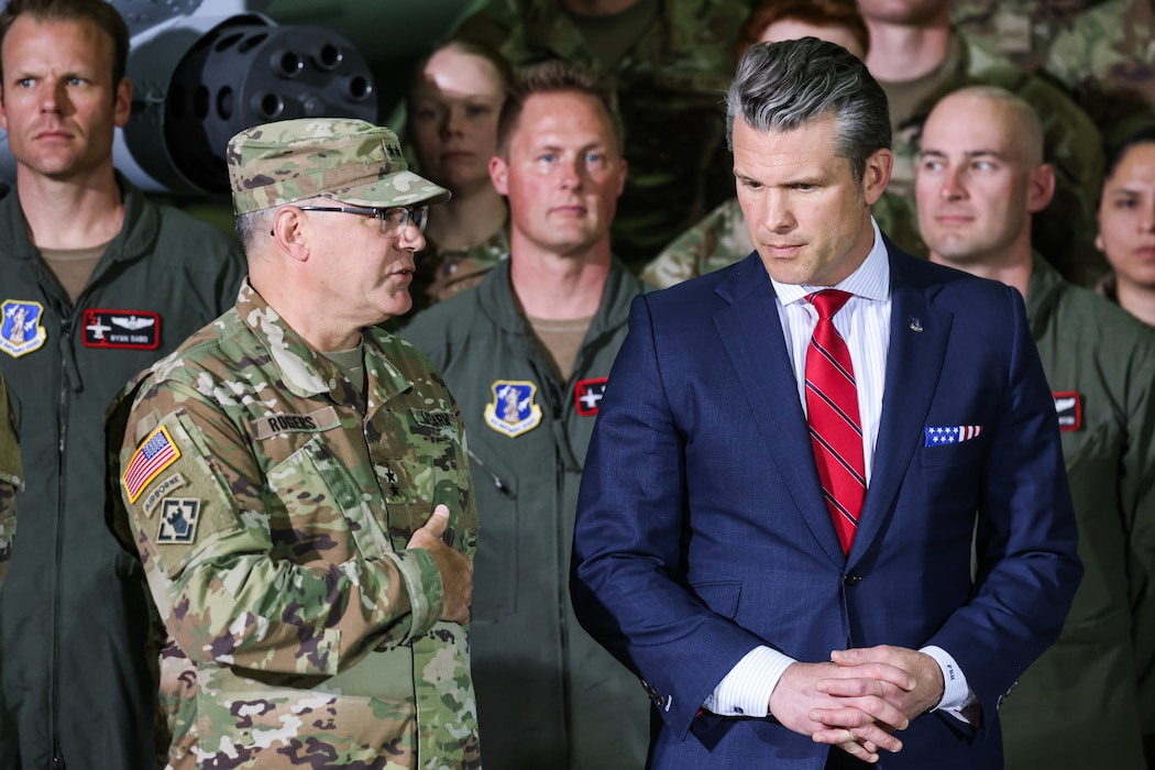 uniformed service member speaks to man in business suit.