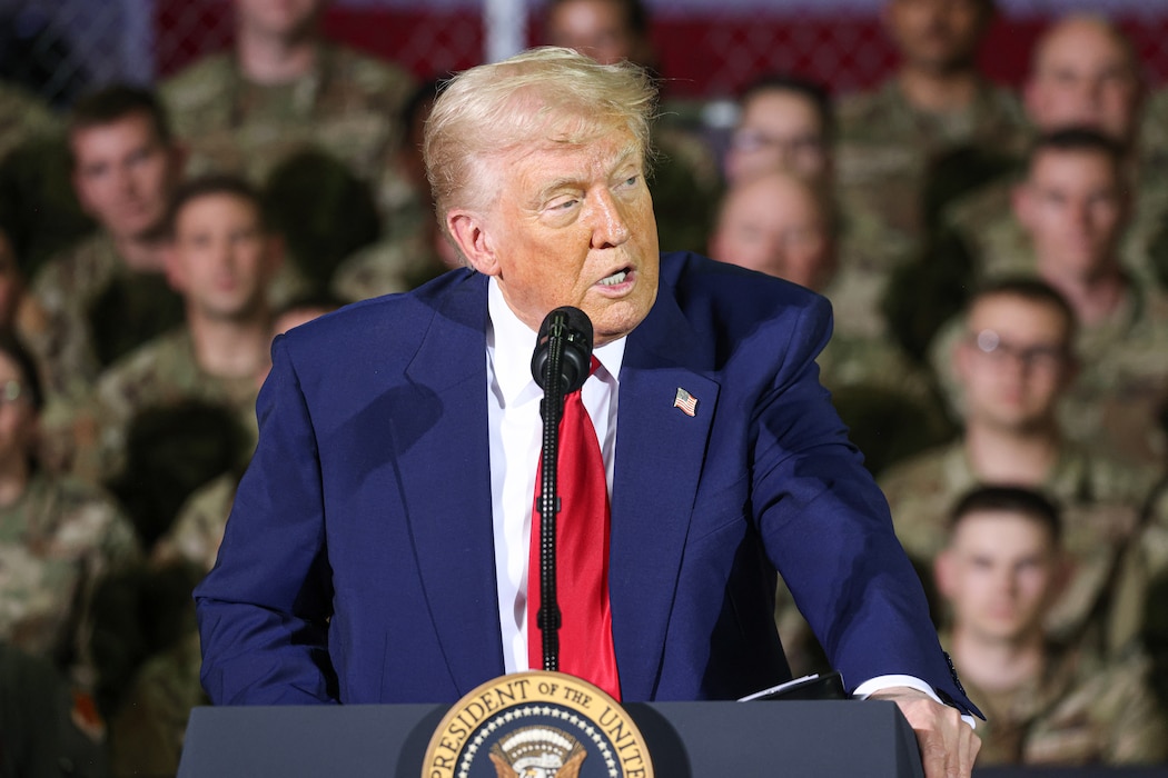 President speaks behind podium with uniformed servicemembers in the background