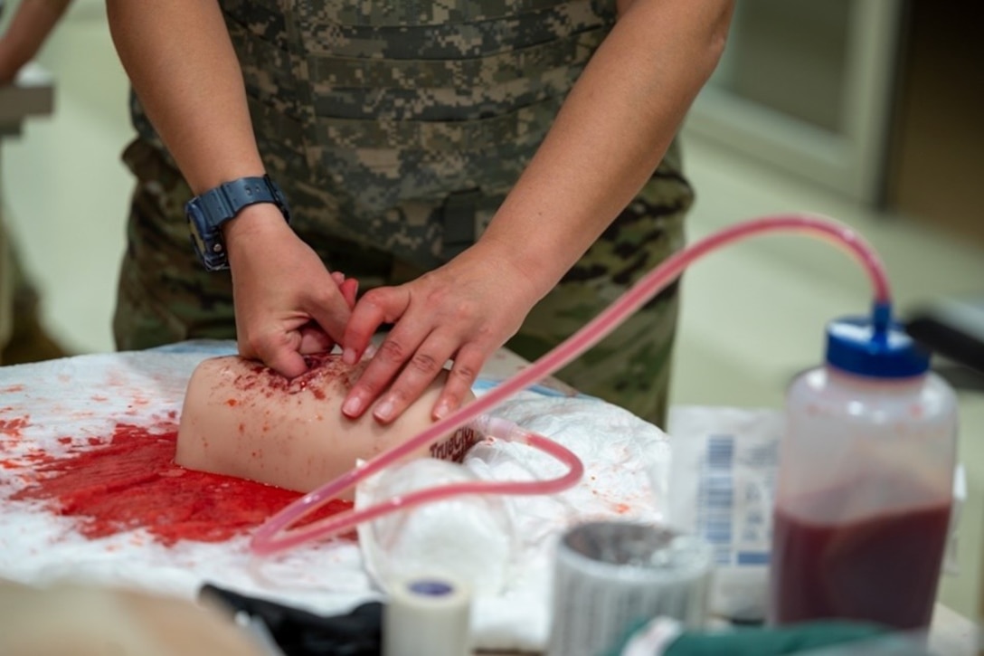 Airman digs finger into mannequin limb. (U.S. Air Force photo by Airman 1st Class Donnell Ramsey)
