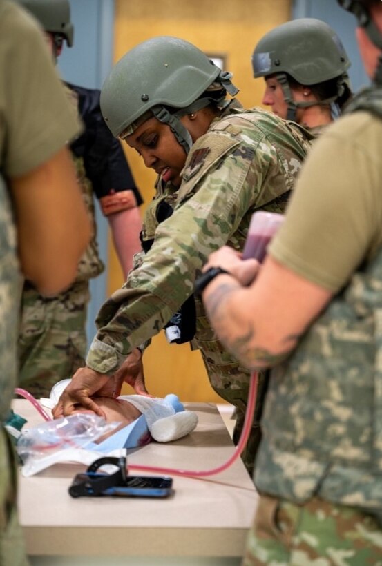 Airman packs bandage into mannequin limb. (U.S. Air Force photo by Airman 1st Class Donnell Ramsey)