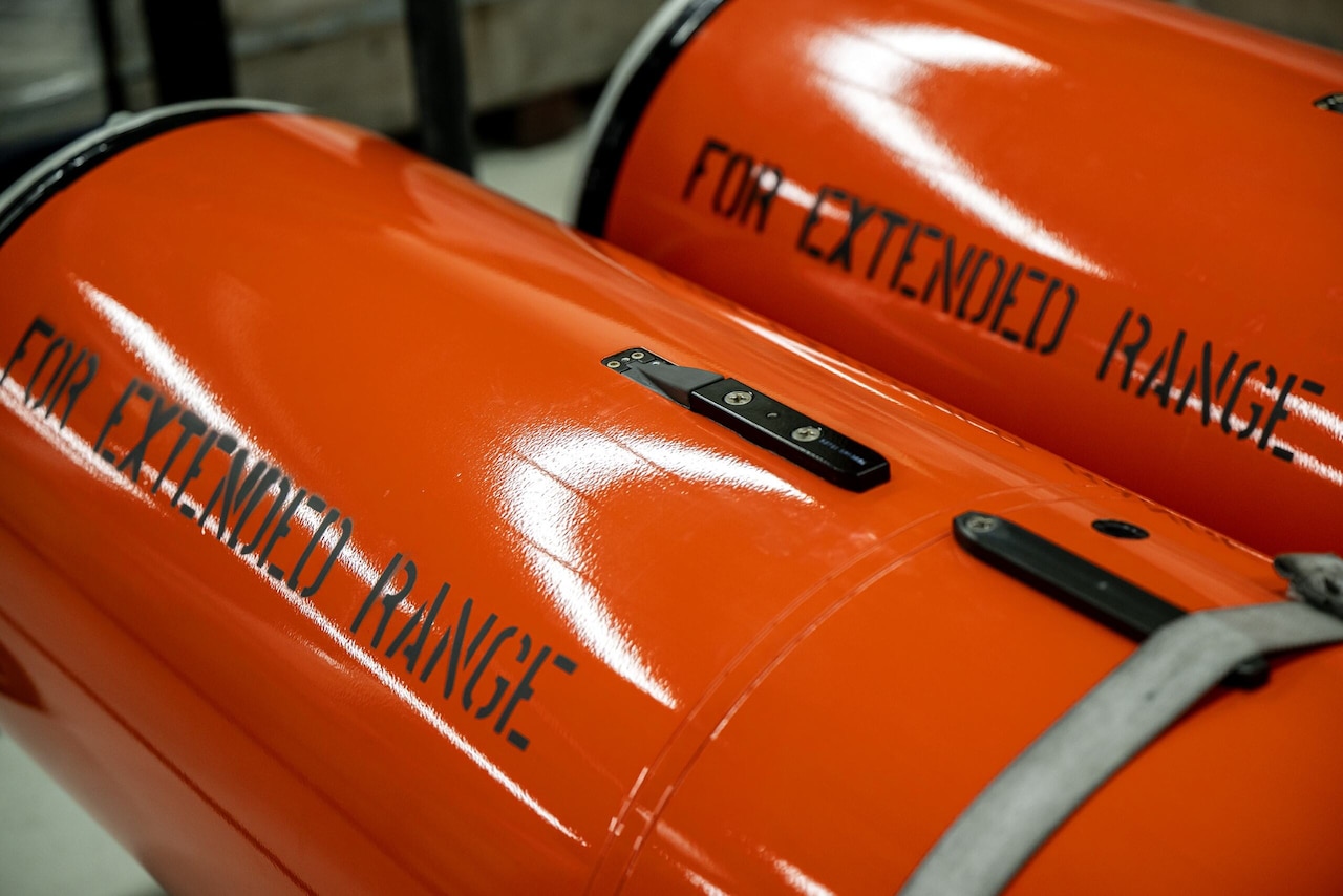 Two orange cylindrical tanks are beside each other. The tanks have “For Extended Range” written on them.
