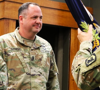 Command Sgt. Maj. Jonathan Genisio waits to receive the 129th Regiment (Regional Training Institute) guidon during the regiment's Change of Responsibility Ceremony.