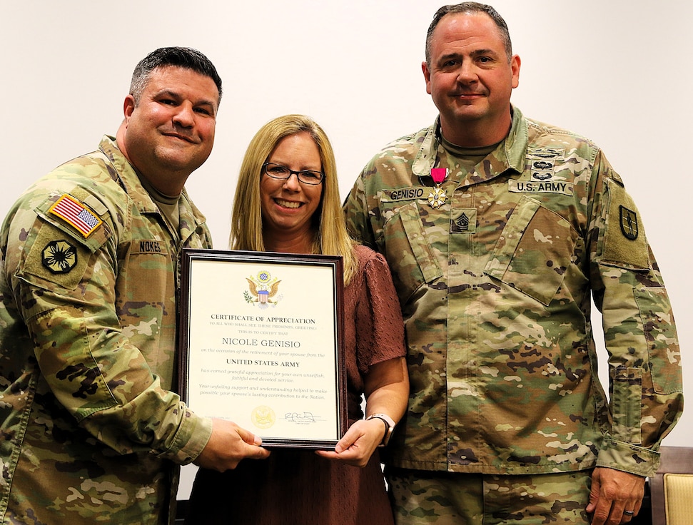 Col. Shawn Nokes, Commander of the 129th Regiment (Regional Training Institute) presents a letter of appreciation from Army Chief of Staff Randy George to Nicole Genisio, spouse of Command Sgt. Maj. Jonathan Genisio.