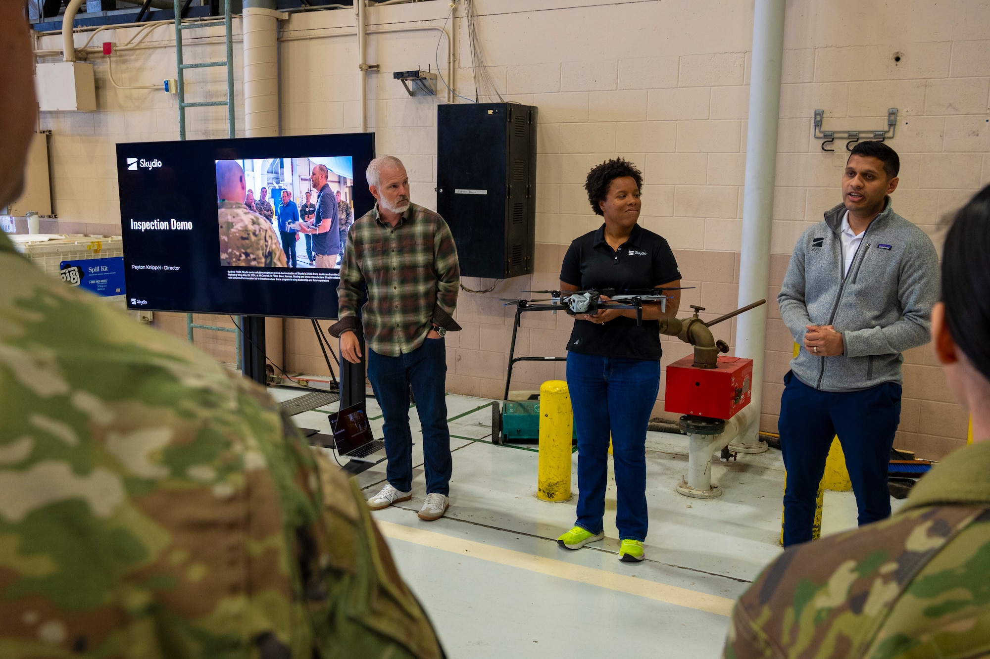 Peyton Knippel, Skydio’s director of Air Force business, left, Uddit Patel, Skydio’s Air Force program manager, right, and Taylor Mitcham, a Skydio senior solutions engineer, highlight the X10D’s capabilities at Joint Base Lewis-McChord, Washington, April 23, 2025.