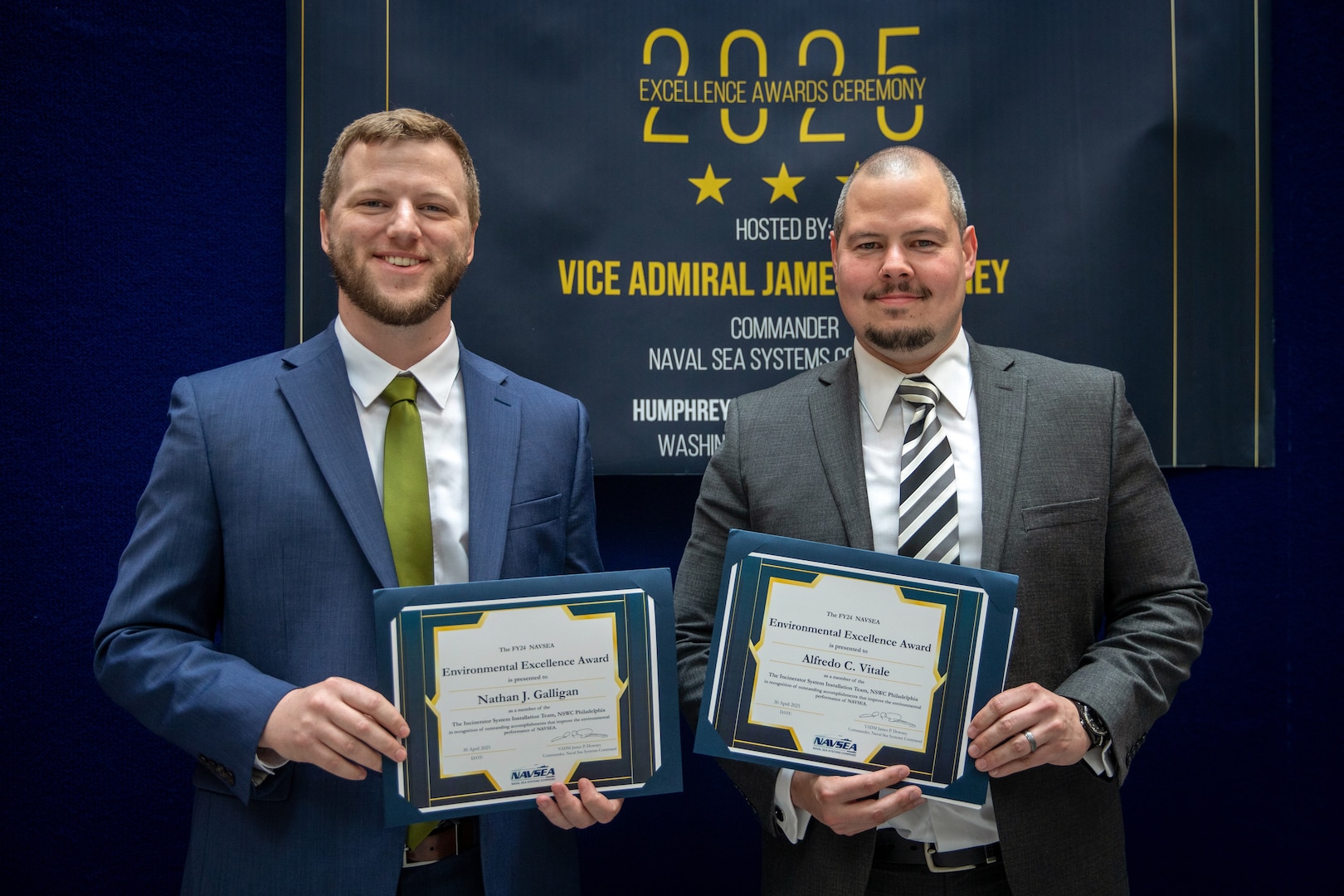 Mr. Alfredo Vitale and Mr. Nathan Galligan accept the fiscal year 2024 Naval Sea Systems Command (NAVSEA) Environmental Excellence Team Award presented to The Incinerator System Installation Team, Naval Surface Warfare Center, Philadelphia, April 30.