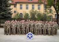 Members of the V Corps Command Team and senior staff members stand together for a group photo with senior leaders from the 1st Armored Division and various supporting units during the Spring Senior Leaders Forum, April 25, 2025, Camp Kościuszko, Poland. Over the course of two learning days, senior leaders used the opportunity to discuss talking points such as crisis response, interoperability, and sustaining over distance. As the forum concluded, leaders were ready to further bolster their unit’s readiness within Victory Corps’ area of operations across Europe. (U.S. Army photo by Sgt. Devin Klecan)