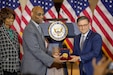 Speaker of the House, Rep. Mike Johnson (R-La.), presents the Congressional Gold Medal to Stanley Earley III, son of 6888th Central Postal Directory Battalion commander Lt. Col. Charity Adams Earley, during a ceremony in Emancipation Hall at the U.S. Capitol building. Judith Earley (left), Lt. Col. Adams Earley's daughter, was also present to help accept the medal.