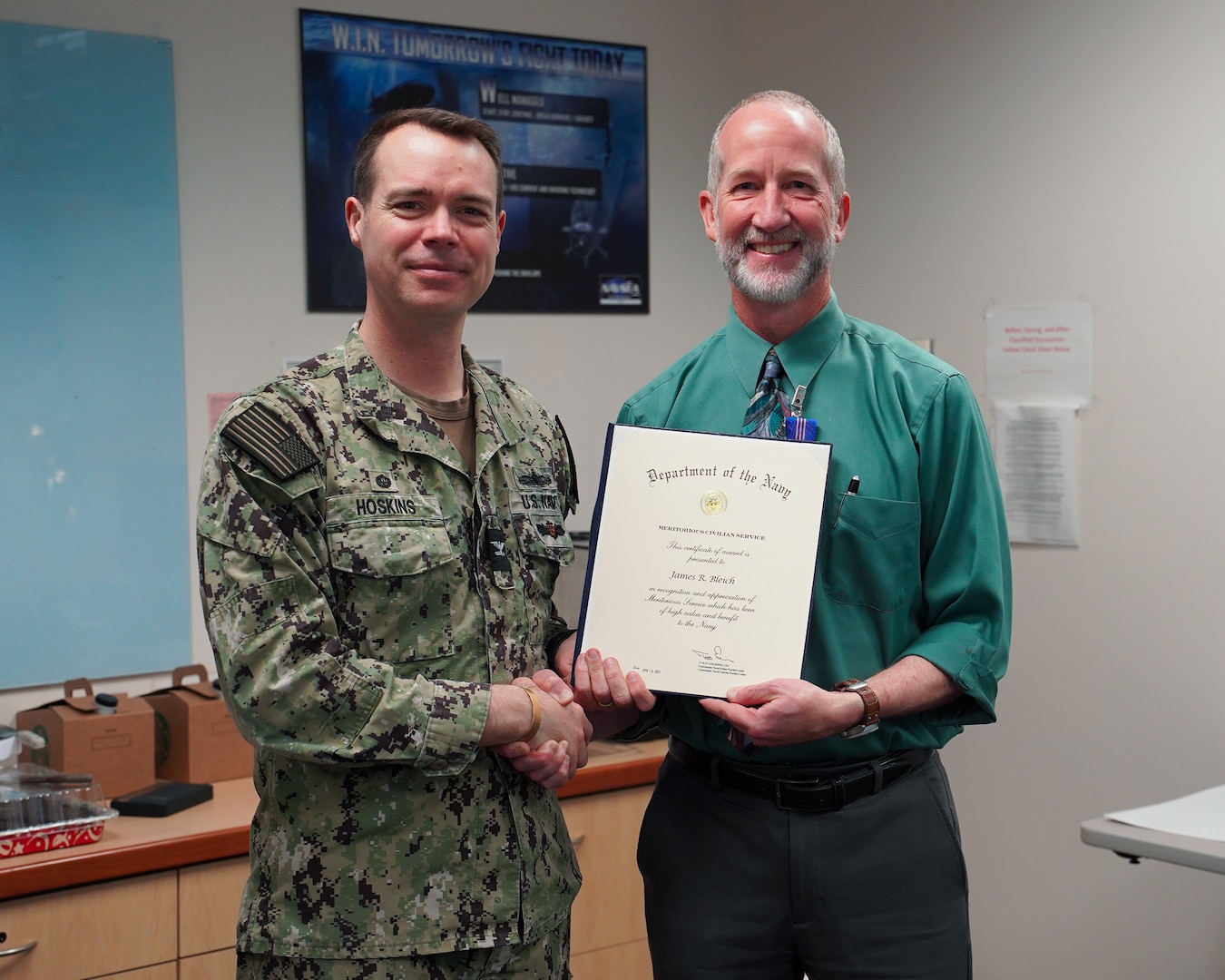 Capt. Clint Hoskins, Commanding Officer, Naval Undersea Warfare Center Division, Keyport, presents NUWC Division, Keyport Acting Technical Director Jim Bleich with a Department of the Navy Meritorious Civilian Service Award, April 24. (U.S. Navy photo by Anna Taylor/Released)