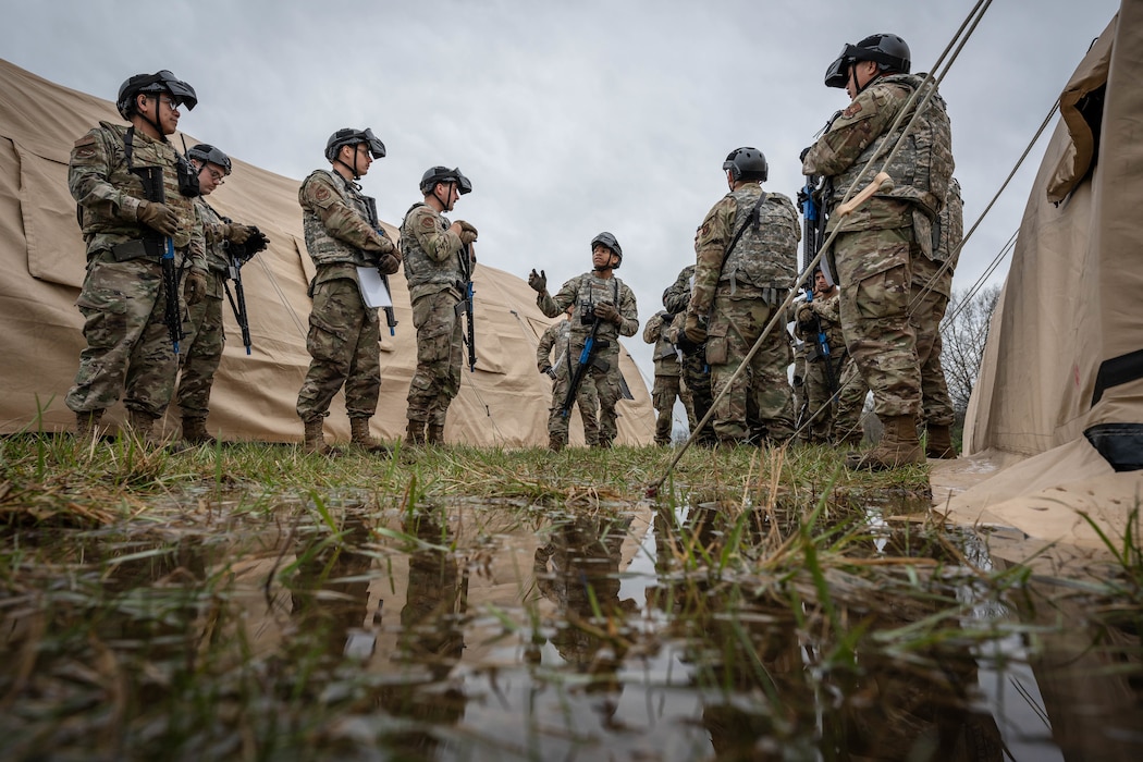 Ground transportation operators assigned to the 509th Logistics Readiness Squadron discuss training tactics during a field training exercise at Whiteman Air Force Base, Missouri, April 3, 2025. The exercise incorporated convoy transport and route reconnaissance, bare base operations, casualty carries, trauma response, and battle drills in a simulated combat environment. (U.S. Air Force photo by Senior Airman Joshua Hastings)
