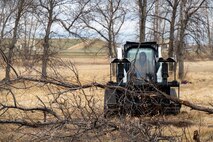 U.S. Air Force Wildland Fire Branch crew member collects Russian Olive trees that were cut down on Minot Air Force Base, North Dakota, April 22, 2025. The Wildland Branch helps protect Air Force personnel and property from wildfires by clearing away dangerous plants and other things that can easily catch fire. (U.S. Air Force photo by Senior Airman Alexander Nottingham)