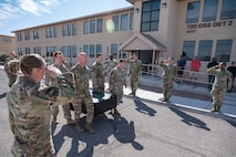 Airmen saluting memorial box.
