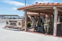 Four Airmen carrying memorial outside.