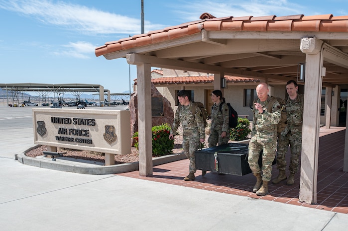 Four Airmen carrying memorial outside.
